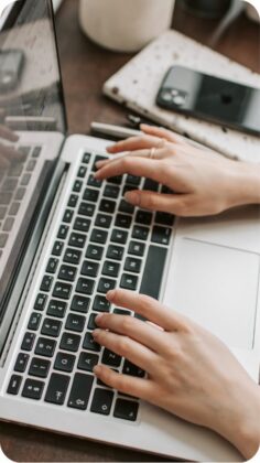 Hands typing on a laptop keyboard